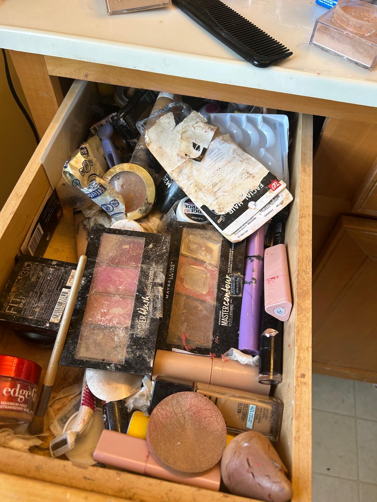 Cluttered, dusty makeup drawer before organizing and cleaning