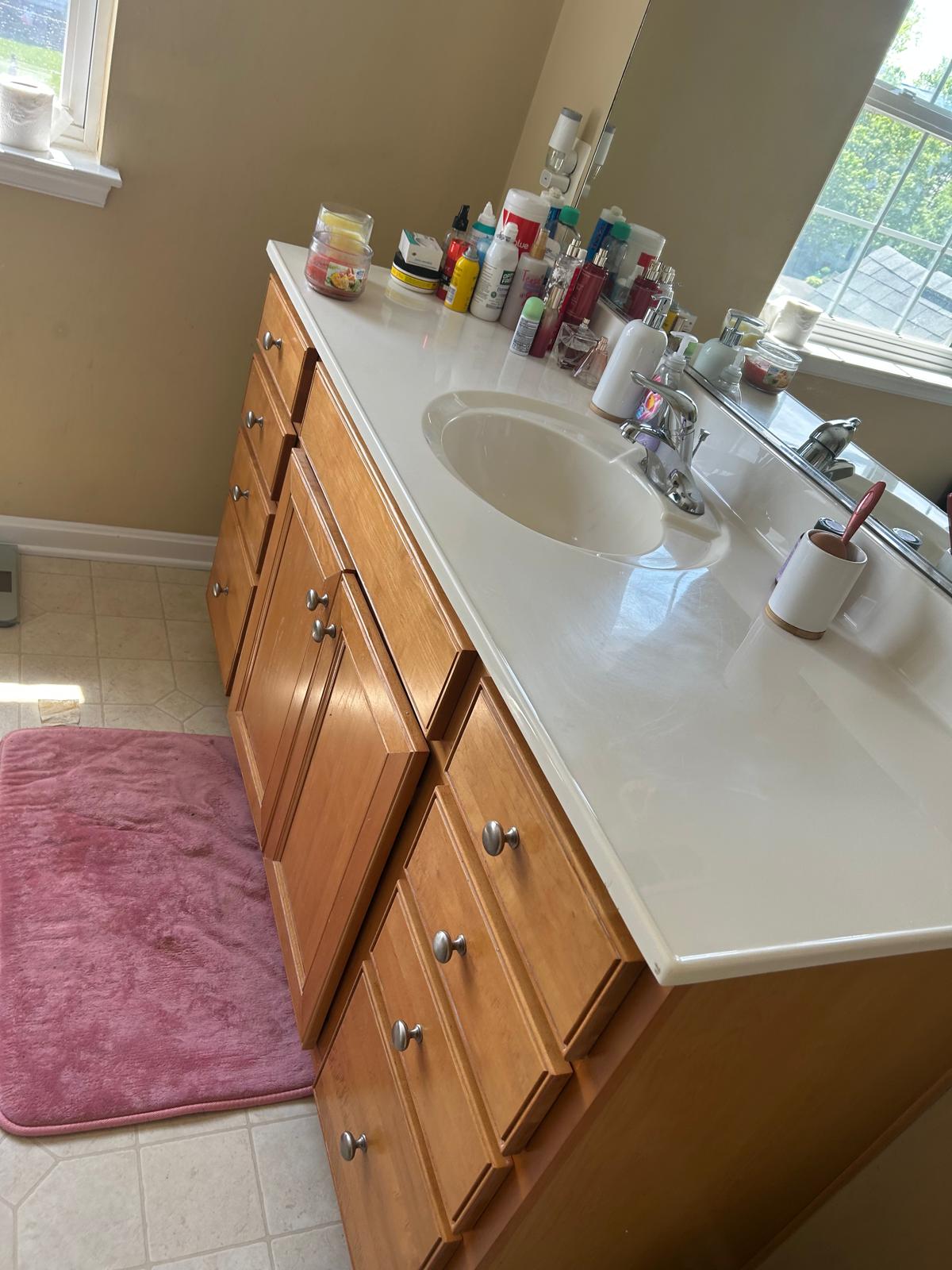 Cluttered bathroom vanity countertop before cleaning
